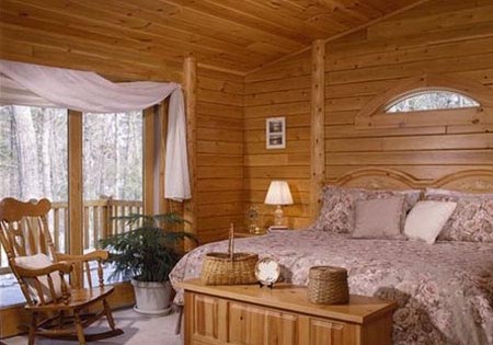 Log home bedroom with eyebrow window