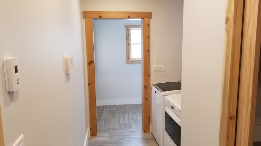 View of laundry room with wood trim