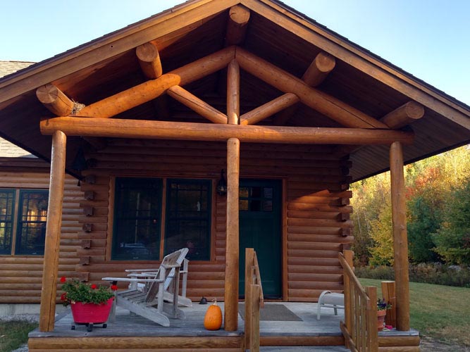 Log home entrance with exposed truss