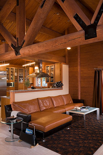 Sitting area with log truss and leather furniture 