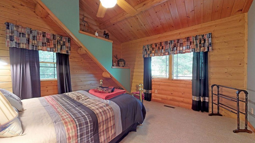 Log home bedroom with wood wall mixed with drywall painted blue