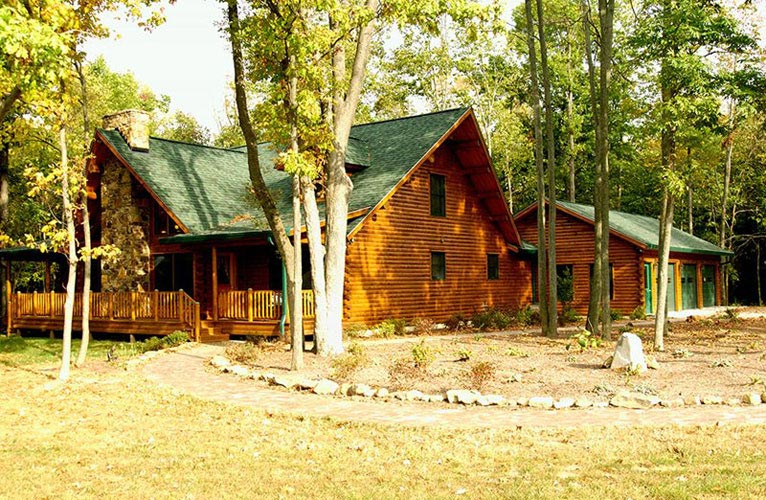 Exterior view of Indy log home surrounded by trees