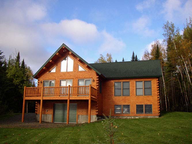 Log home Exterior with daylight basement and deck above