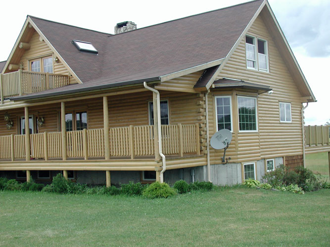 Log home with deck and balcony in front