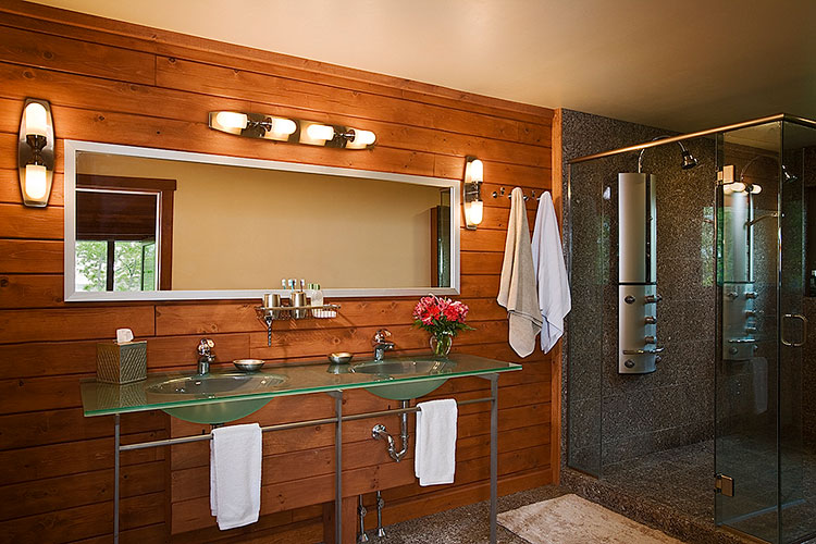 Modern log home bathroom with double sink and glass countertop