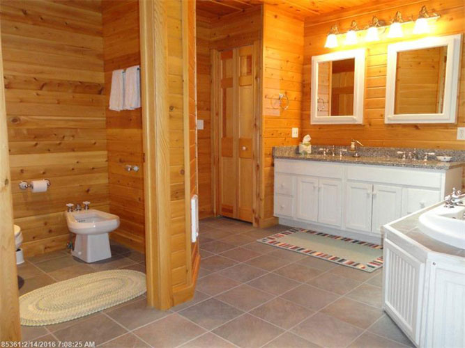 Large log home bathroom with separate quarters for urinal and toilet