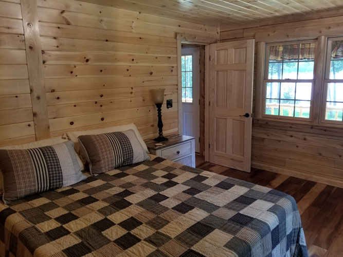 Checkered comforter in bedroom of Musquash log cabin