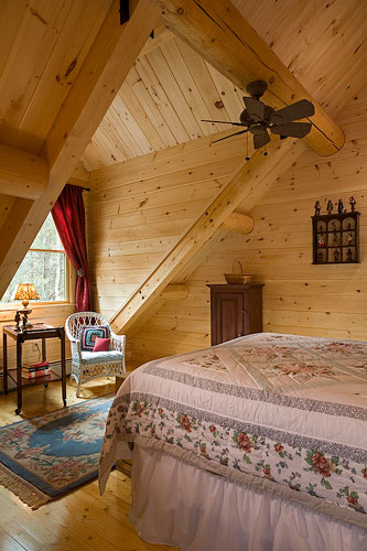 Log home bedroom with large gable dormer for sitting area