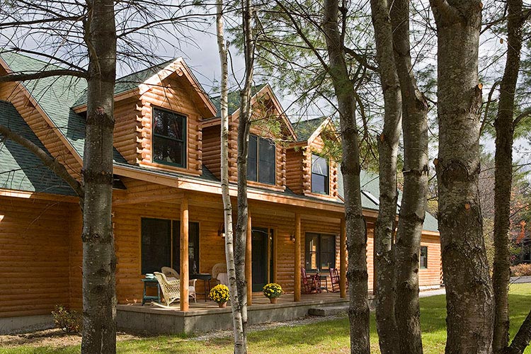 Exterior of log home looking through trees