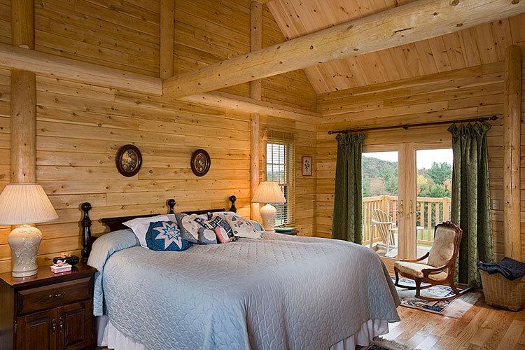 Log home master bedroom with exposed beams