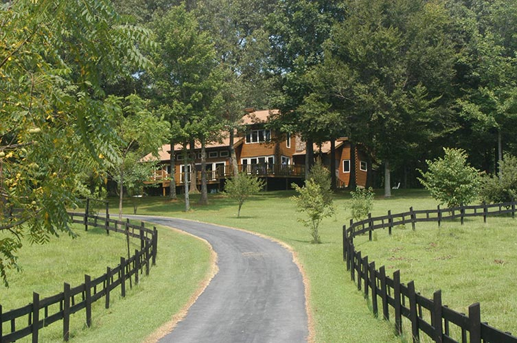 Paved driveway leading up to log home