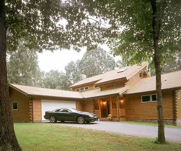 Black car parked in front of log home